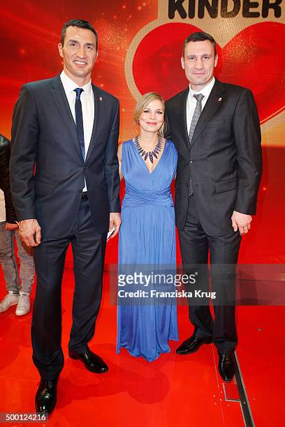 Wladimir Klitschko, Regina Halmich and Vitali Klitschko attend the Ein Herz Fuer Kinder Gala 2015 show at Tempelhof Airport on December 5, 2015 in...