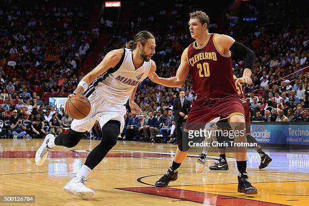 Josh McRoberts of the Miami Heat dribbles the ball under pressure from Timofey Mozgov of the Cleveland Cavaliers at American Airlines Arena on...