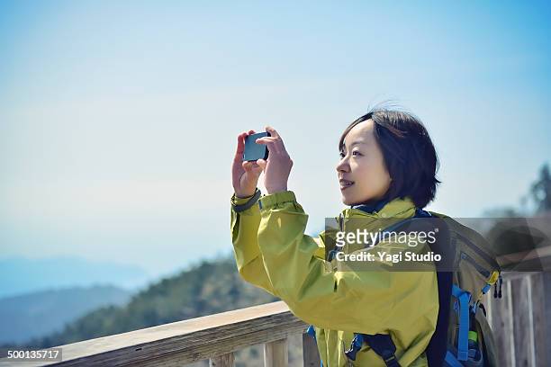 woman using smartphone in the mountains - アウトドア　日本人 ストックフォトと画像