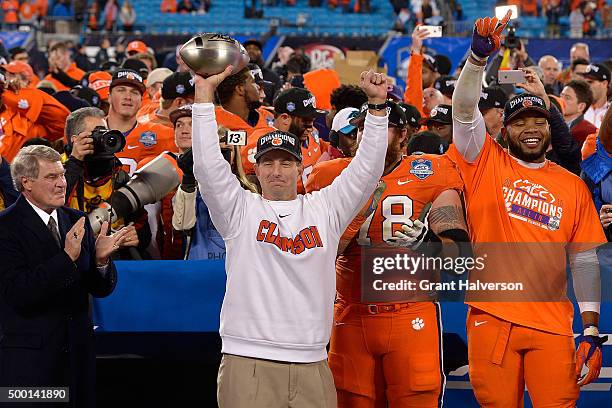 Head coach Dabo Swinney of the Clemson Tigers celebrates with the trophy after a win against the North Carolina Tar Heels during the Atlantic Coast...