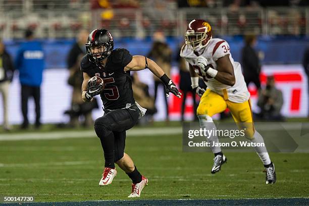 Running back Christian McCaffrey of the Stanford Cardinal rushes up field past linebacker Olajuwon Tucker of the USC Trojans during the third quarter...