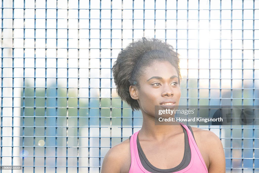 Female athlete standing, back light