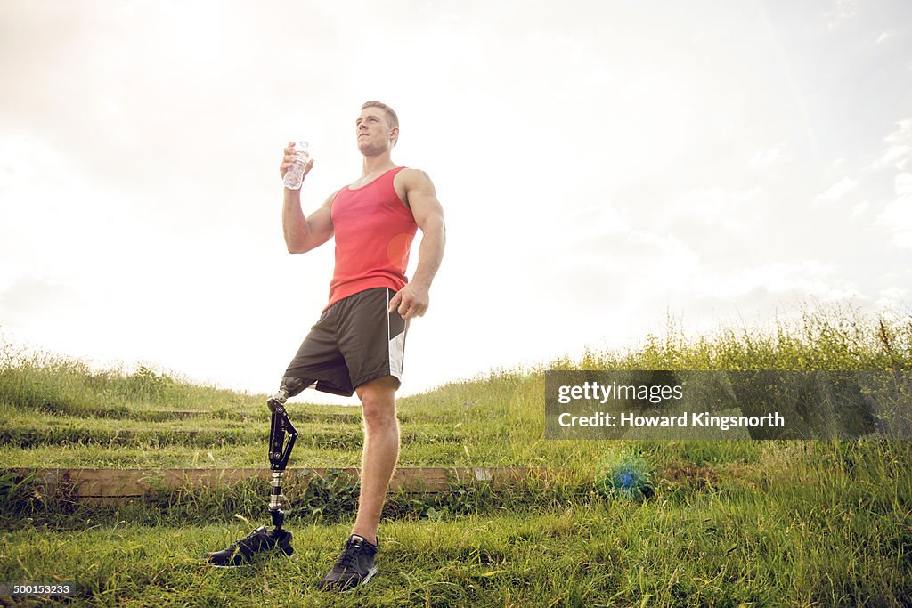 Sporting male amputee drinking water