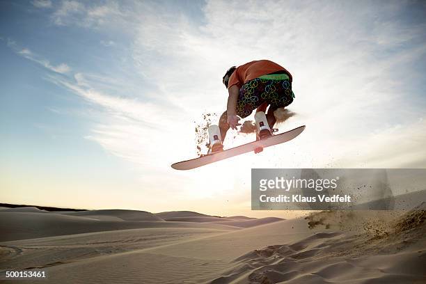 sandboarder doing front side grab in the air - extreme depth of field stock pictures, royalty-free photos & images