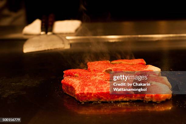 raw beef on the hot iron plate (teppanyaki steak) - teppanyaki stock pictures, royalty-free photos & images