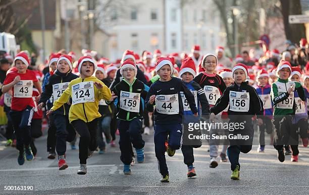 Children wearing santa Claus caps start in children's 1km race of the 7th annual Michendorf Santa Run on December 6, 2015 in Michendorf, Germany. A...
