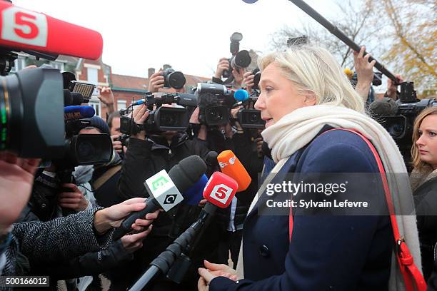 French Far-Right National Front President Marine Le Pen talks with journalists as she leaves the polling station after voting for the first round of...