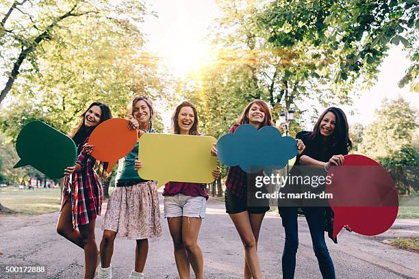 happy friends with speech bubbles smiling to the camera - holding speech bubble stock pictures, royalty-free photos & images