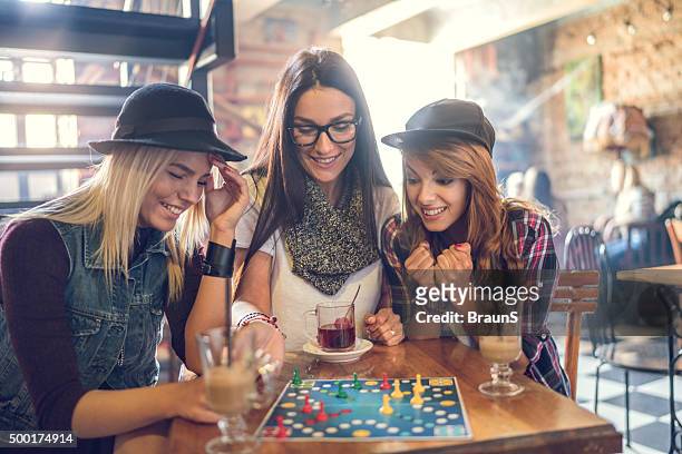 happy friends playing cross and section game in a cafe. - boardgame stockfoto's en -beelden