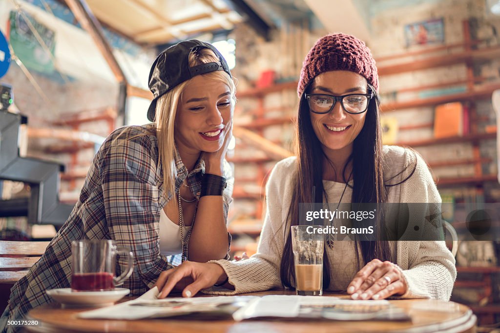 Junge glückliche Frauen in einem Café entspannen und lesen Magazin.