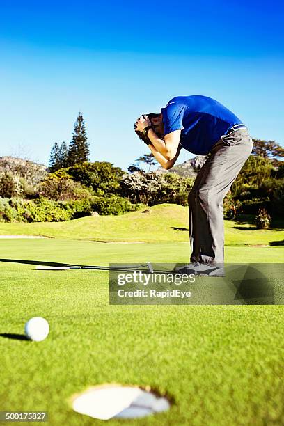 missed putt! unhappy golfer holds his head in frustrated shame - angry golfer stock pictures, royalty-free photos & images