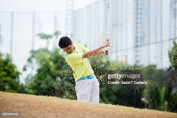 male golfer hitting golf ball out of a sand trap - spectacles bunkers stock pictures, royalty-free photos & images