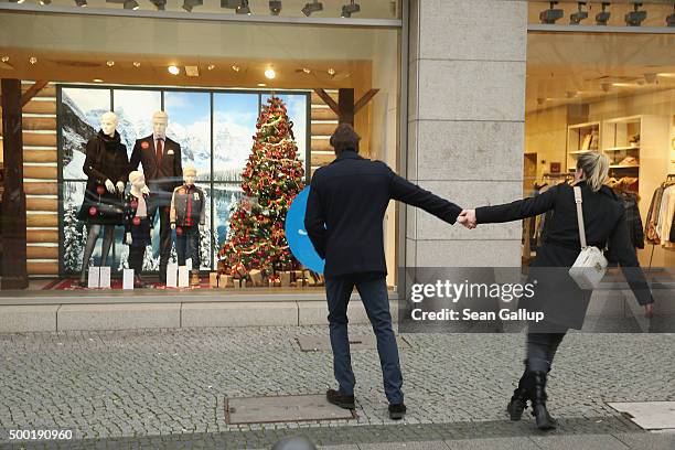 Couple are tempted by a shop display window on a shopping Sunday on December 6, 2015 in Berlin, Germany. Stores are usually closed on Sundays in...