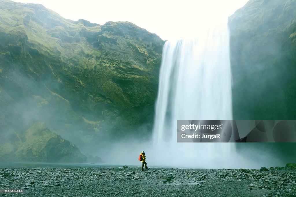 Wanderer am majestätischen Skogafoss-Wasserfall in Island