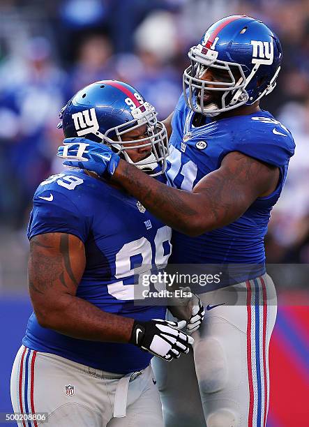 Damontre Moore of the New York Giants celebrates with teammates Robert Ayers after a tackle against the New York Jets at MetLife Stadium on December...