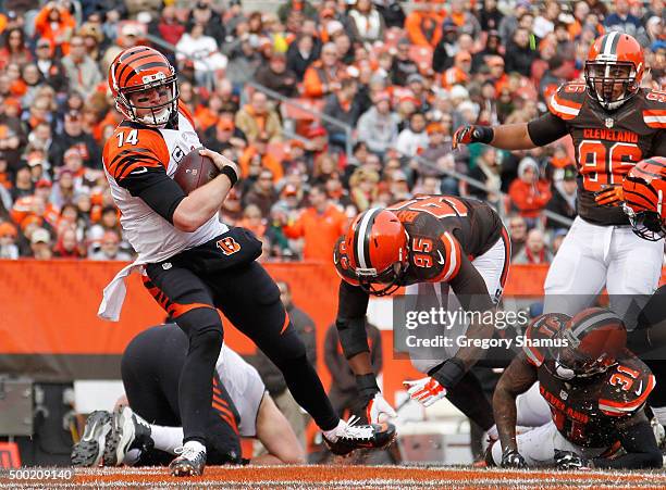 Andy Dalton of the Cincinnati Bengals runs for a first quarter touchdown past Armonty Bryant and Donte Whitner of the Cleveland Browns at FirstEnergy...