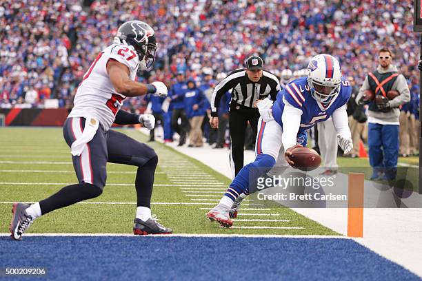 Tyrod Taylor of the Buffalo Bills runs for a touchdown as Quintin Demps of the Houston Texans defends during the first half at Ralph Wilson Stadium...