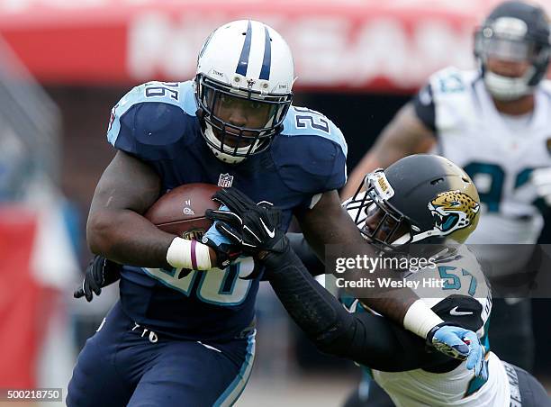 Antonio Andrews of the Tennessee Titans attempts to break a tackle attempt by Thurston Armbrister of the Jacksonville Jaguars during the game at...