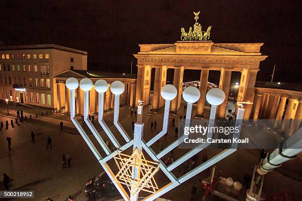 The area is illuminated after the lighting of the Hanukkah menorah at a public Menorah ceremony near the Brandenburg Gate on December 6, 2015 in...