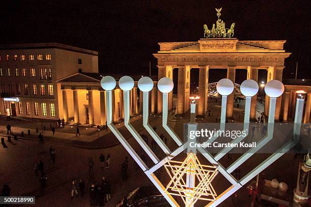 The area is illuminated after the lighting of the Hanukkah menorah at a public Menorah ceremony near the Brandenburg Gate on December 6, 2015 in...