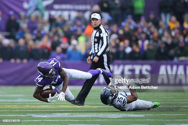 Stefon Diggs of the Minnesota Vikings gets tripped up by DeShawn Shead of the Seattle Seahawks while Referee Terry McAulay watches in the second...