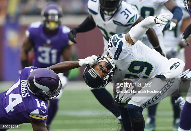 Stefon Diggs of the Minnesota Vikings grabs the face-mask of Earl Thomas of the Seattle Seahawks after an interception by Thomas during the second...