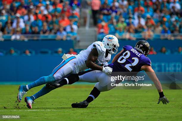 Nick Boyle of the Baltimore Ravens is tackled by Reshad Jones of the Miami Dolphins at Sun Life Stadium on December 6, 2015 in Miami Gardens, Florida.