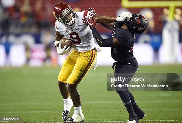 JuJu Smith-Schuster of the USC Trojans stiff arms Ronnie Harris of the Stanford Cardinal during the second quarter of the NCAA Pac-12 Championship...