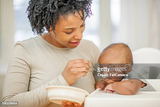 mother feeding her toddler - mother baby food stock pictures, royalty-free photos & images