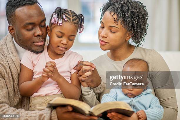 praying together as a family - couple praying stock pictures, royalty-free photos & images