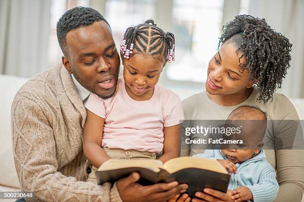 reading the bible together as a family - bible stock pictures, royalty-free photos & images