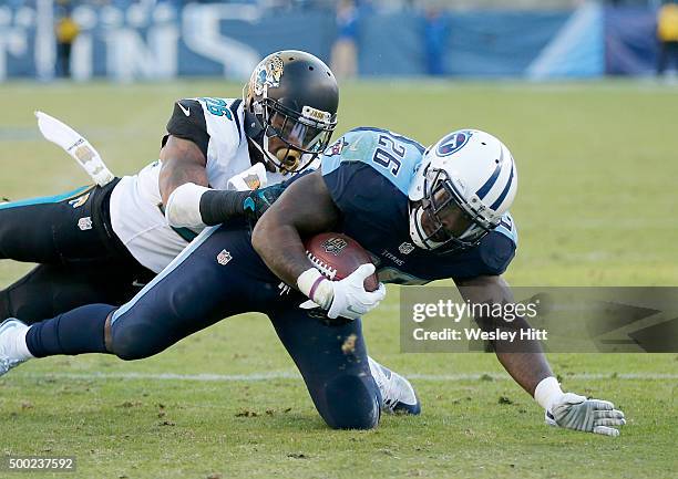 Antonio Andrews of the Tennessee Titans is brought down by Josh Evans of the Jacksonville Jaguars during the game at Nissan Stadium on December 6,...