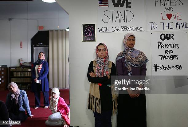 Khadija Zadeh and Noora Siddiqui stand together as they attend an interfaith service at the Islamic Community Center of Redlands for the victims of...
