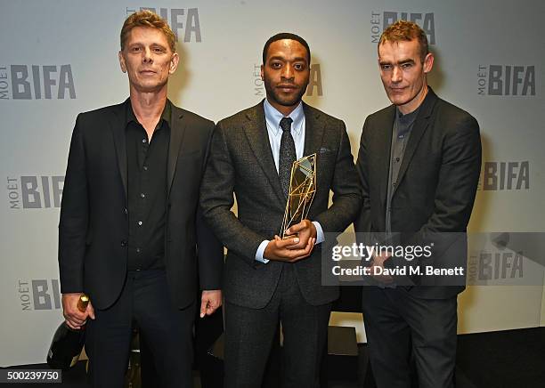 Chiwetel Ejiofor , winner of the Richard Harris award, poses with Jamie Harris and Rufus Norris at the Moet British Independent Film Awards 2015 at...