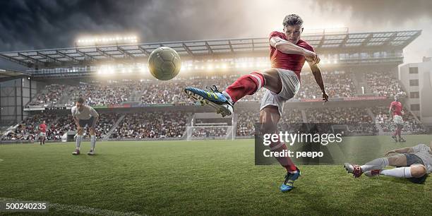 football joueur shootant dans un ballon - his foot photos et images de collection