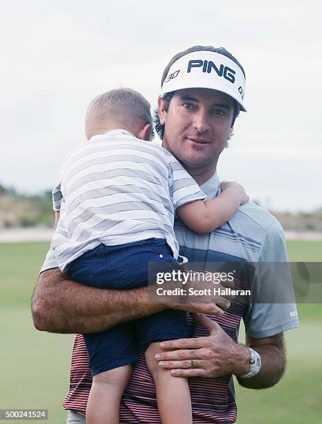 Bubba Watson of the United States walks with his son Caleb off the 18th green after his three-stroke victory at the Hero World Challenge at Albany,...