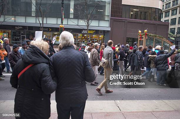 Shoppers stop to watch as demonstrators led by Rev. Jesse Jackson march down State Street to protest the death of Laquan McDonald and the alleged...