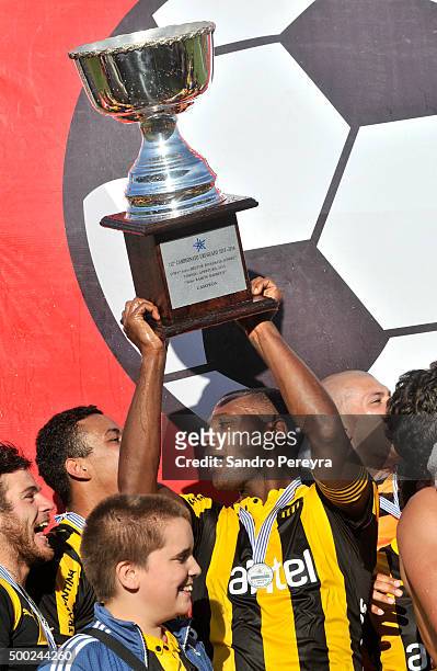 Marcelo Zalayeta of Peñarol raises the trophy after a match between Penarol and Juventud as part of Torneo Apertura 2015 at Centenario Stadium on...