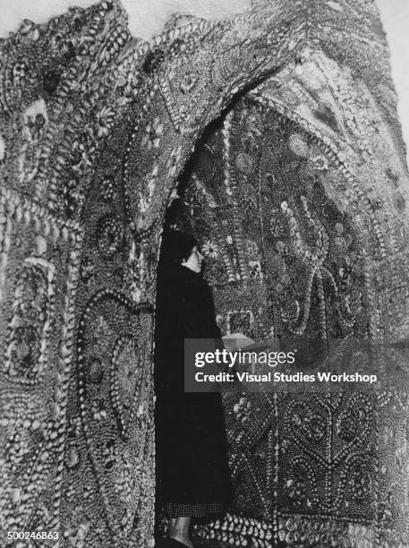 Visitor admires one of the walls of the Shell Grotto, an underground temple decorated entirely with seashells in mosaic patterns and flowers and...