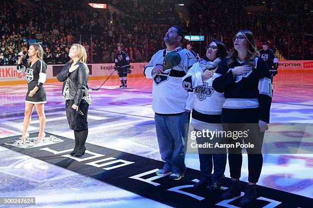 Joey Nardone, Vicki Nardone, and Sammy Hydecker stand on ice in honor of their fallen family member Woody David Taylor Nardone as part of the Los...