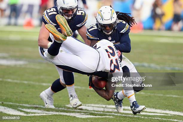 Running back Ronnie Hillman of the Denver Broncos goes airborn as he carries the ball against safety Jahleel Addae and linebacker Kyle Emanuel of the...
