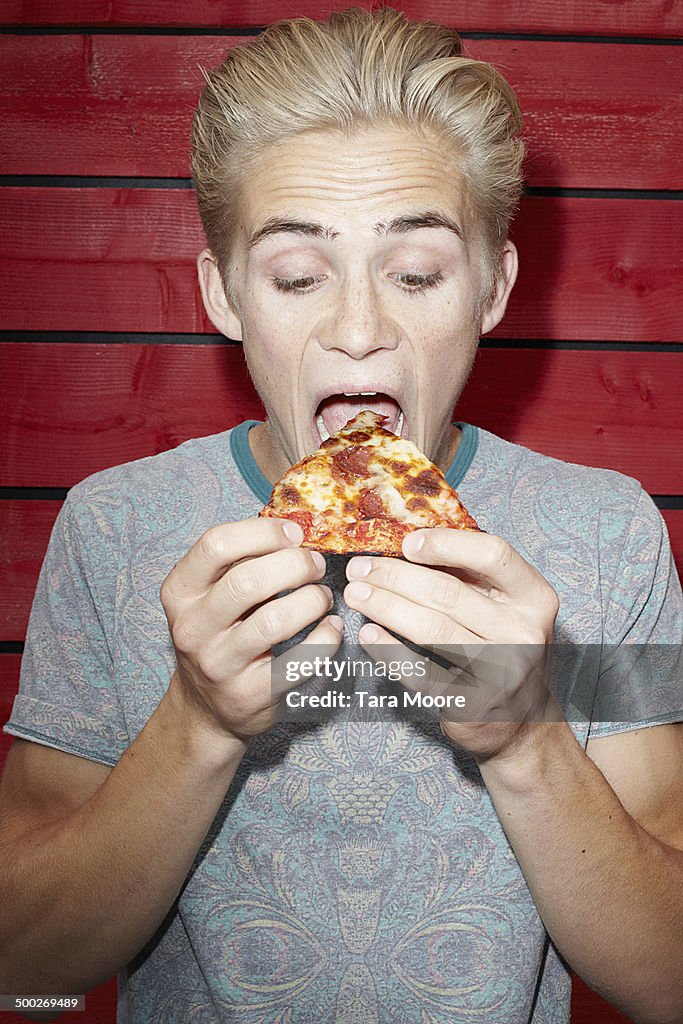 Young man eating pizza