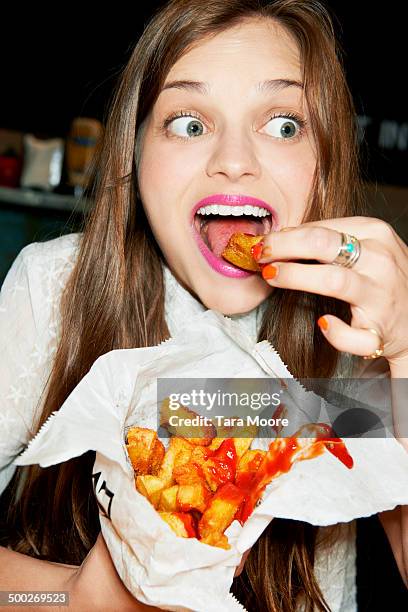 woman eating bag of ships - patatas fritas tentempié fotografías e imágenes de stock