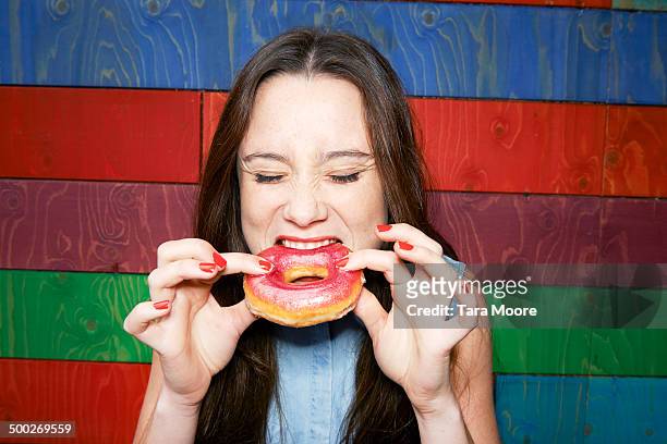 woman eating donut - eating donuts foto e immagini stock