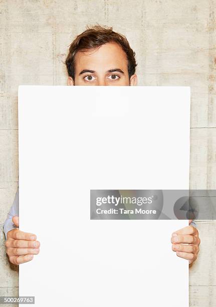 man holding white message board - tablón de anuncios fotografías e imágenes de stock