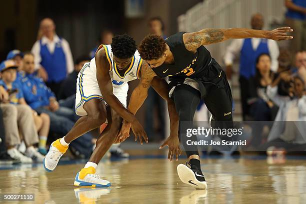 Isaac Hamilton of the UCLA Bruins and Nick Faust of the Long Beach State 49ers fight for a loose ball in the first period at Pauley Pavilion on...