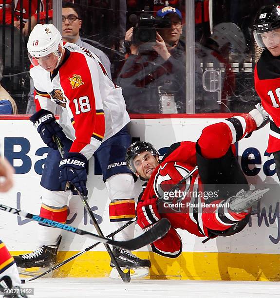 Reilly Smith of the Florida Panthers takes down Stephen Gionta of the New Jersey Devils on a bodycheck during the third period of an NHL hockey game...