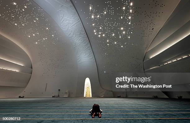 Man prays in the mosque at the Qatar Faculty of Islamic Studies on the Education City campus in Doha, Qatar, on November 5, 2015. The building,...