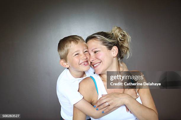 a 7 years old boy hugging his mom - 30 34 years stock-fotos und bilder