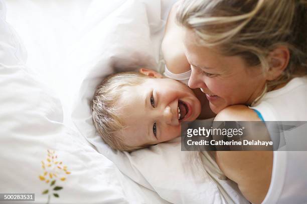 a 3 years old boy in his bed with his mom - 2 3 years stock-fotos und bilder